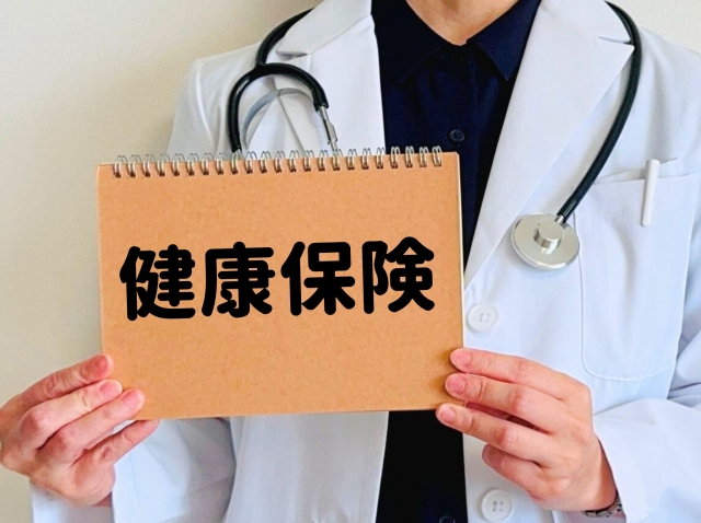 健康保険と書かれていた札を持っている男性