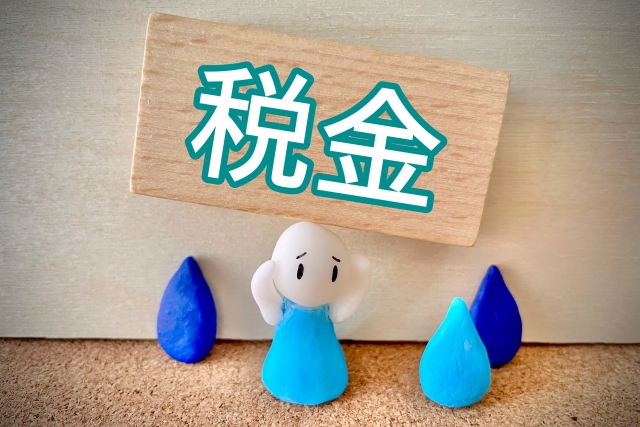 税金と書かれた札と人形